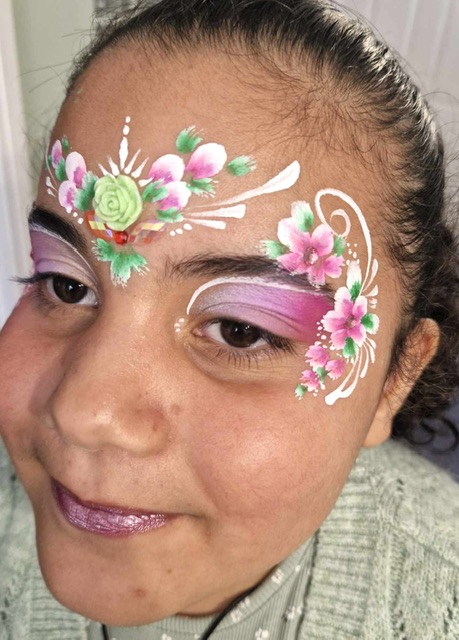 girl with pink flowers face painted in Telford